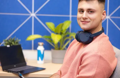 Blog "Okiem Praktyków" | Uniwersytet WSB Merito: Chłopak z laptopem w niebieskim