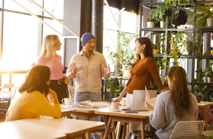 Poradniki - dzielimy się wiedzą | Uniwersytet WSB Merito: Grupa ludzi rozmawiająca w jasnym pomieszczeniu