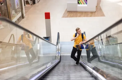 Blog "Okiem Praktyków" | Uniwersytet WSB Merito: Mężczyzna rozmawiający przez telefon na ruchomych schodach