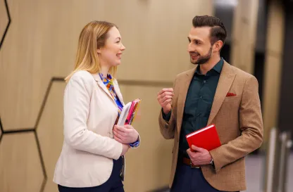 Poradniki - dzielimy się wiedzą | Uniwersytet WSB Merito: Dwie osoby rozmawiające na korytarzu