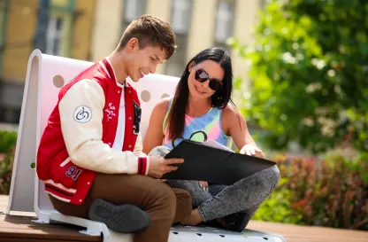 Blog "Okiem Praktyków" | Uniwersytet WSB Merito: Dwie osoby czytające dokument na świeżym powietrzu