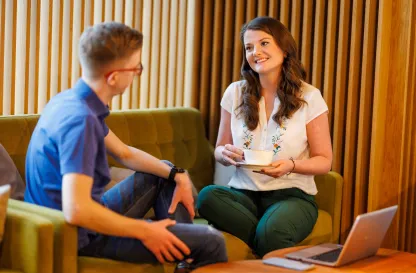 Poradniki - dzielimy się wiedzą | Uniwersytet WSB Merito: dwoje studentów rozmawiaja siedząc na fotelu