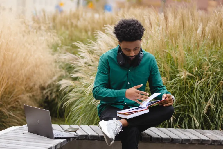 Jak unikać błędów w podejmowaniu decyzji? | Blog "okiem praktyków" | Uniwersytet WSB Merito: Mężczyzna czytający książki na świeżym powietrzu