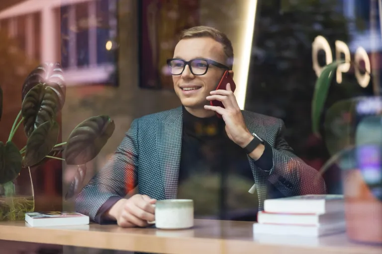 Jaki zawód wybrać - zobacz zawody pewnej przyszłości | Uniwersytet WSB Merito: Mężczyzna rozmawiający przez telefon, wpatrujący się w okno