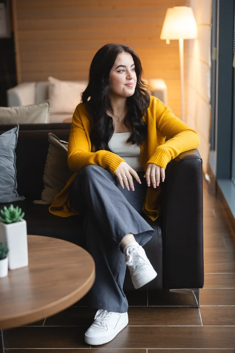 Studia prawnicze - tylko dla ambitnych | Uniwersytet WSB Merito: Dziewczyna siedząca na fotelu, wpatrująca się w okno