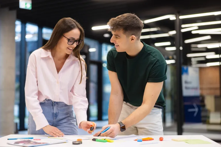 Neurorewolucja w marketingu | Blog "okiem praktyków" | Uniwersytet WSB Merito: Dwoje ludzi pracujących z papierami w sali