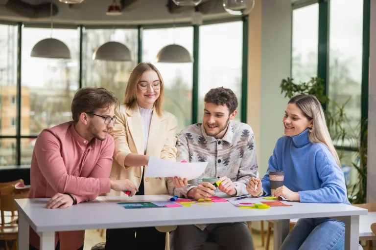 Wyniki wyszukiwania | Uniwersytet WSB Merito: Grupa ludzi przy stole dyskutująca o dokumentach