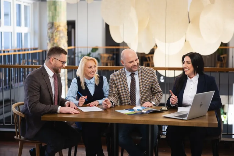 Jak ESG wpływa na przedsiębiorców? | Blog "okiem praktyków" | Uniwersytet WSB Merito: czterech uczestników MBA siedzi przy stole i rozmawia- Uniwersytety WSB Merito