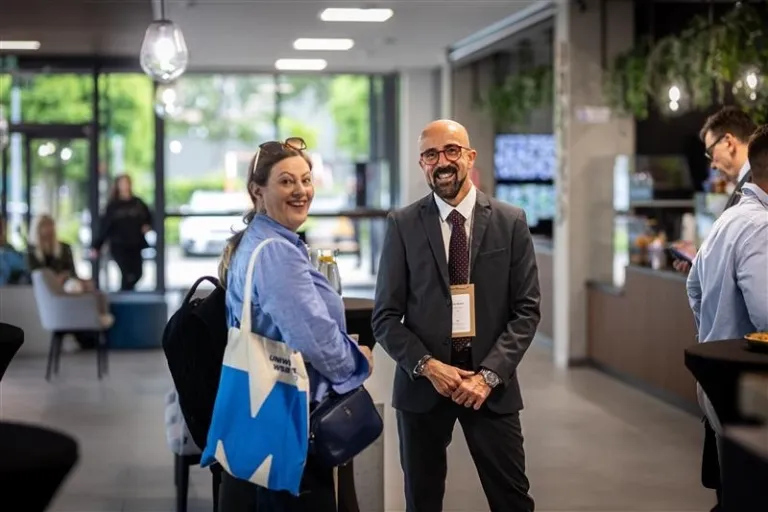 Studia MBA - nowy krok na drodze do kariery | Uniwersytet WSB Merito: Uczestnik i uczestniczka konferencji z widocznym logotypem Merito na torbie