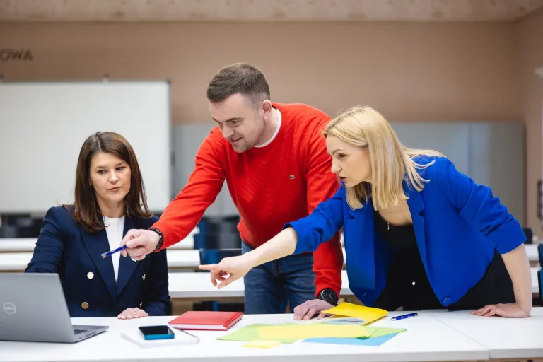 Kim jest UX designer i jak wygląda jego praca? | Uniwersytet WSB Merito: Troje ludzi wskazujących na ekran laptopa