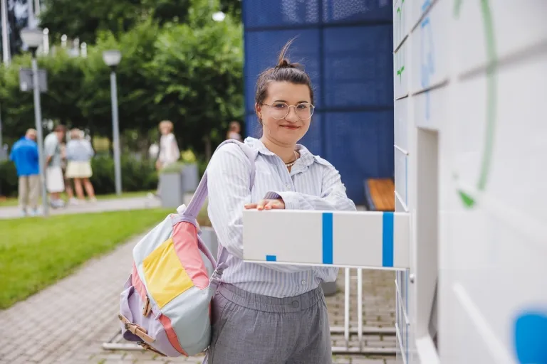 Praca po studiach ekonomicznych - poradnik dla tych, którzy chcą rozpocząć pracę już na studiach lub tuż po ich ukończeniu | Uniwersytet WSB Merito: Kobieta przy książkomacie