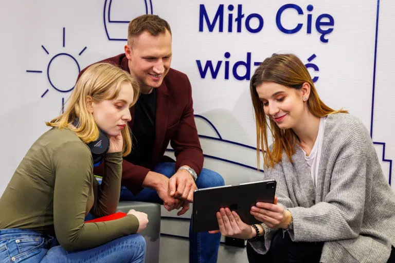 Czy szefowi potrzebne są studia? | Uniwersytet WSB Merito: Troje młodych ludzi wpatrujących się w ekran tableta