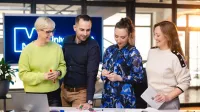 Audyt wewnętrzny i kontrola w organizacji | Studia podyplomowe w Szczecinie | Uniwersytet WSB Merito Szczecin: Cztery osoby pracują nad projektem, otoczone notatkami i materiałami.