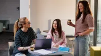 Dietetyka kliniczna | Studia I stopnia w Szczecinie | Uniwersytet WSB Merito Szczecin: Trzy dziewczyny rozmawiają przy stoliku z laptopem i notatkami.
