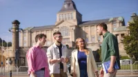 Menadżer przedsiębiorstwa turystycznego | Studia I stopnia w Szczecinie | Uniwersytet WSB Merito Szczecin: Grupa osób rozmawia przed budynkiem.