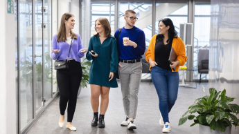 Dydaktyka języków obcych | Uniwersytet WSB Merito Szczecin: Studenci rozmawiają spacerując korytarzem podczas przerwy.