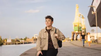 Inspektor Ochrony Danych | Studia podyplomowe w Szczecinie | Uniwersytet WSB Merito Szczecin: Studentka siedzi nad wodą w okolicy portu, patrząc w dal.Studentka siedzi nad wodą w okolicy portu, patrząc w dal.