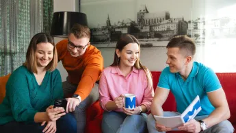 Zarządzanie i inwestowanie w   nieruchomości | Studia podyplomowe w Szczecinie | Uniwersytet WSB Merito Szczecin: Studenci WSB Merito rozmawiają i przeglądają materiały.