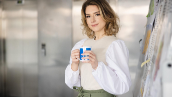 Nowoczesne usługi dla biznesu | Studia I stopnia w Szczecinie | Uniwersytet WSB Merito Szczecin: Studentka Uniwersytetu WSB Merito Szczecin z kubkiem kawy przy tablicy.