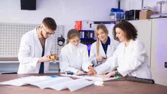 Bezpieczeństwo i higiena pracy | Studia I stopnia w Szczecinie | Uniwersytet WSB Merito Szczecin: Grupa studentów w fartuchach w sali laboratoryjnej