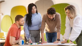 Administracja i bezpieczeństwo wewnętrzne | Studia II stopnia w Szczecinie | Uniwersytet WSB Merito Szczecin: Grupa studentów pracuje zespołowo nad projektem w przyjaznej przestrzeni Uniwersytetu WSB Merito.