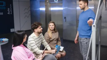 Zarządzanie zasobami ludzkimi | Studia I stopnia w Szczecinie | Uniwersytet WSB Merito Szczecin: Główna grafika: Grupa studentów w korytarzu uczelni