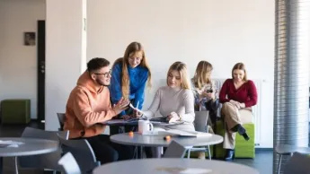 Product Manager w erze AI - zarządzanie produktami cyfrowymi | Studia podyplomowe w Szczecinie | Uniwersytet WSB Merito Szczecin: grupa studentów na korytarzu na Uczelni WSB Merito Szczecin