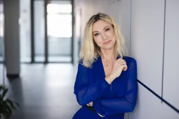 Zasady rekrutacji | Uniwersytet WSB Merito Szczecin: Absolwentka studiów MBA pozuje na korytarzu uczelni- Uniwersytet WSB Merito w Szczecinie