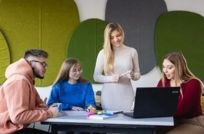 Aktualności | Uniwersytet WSB Merito Szczecin: Studenci robiący projekt przy stole na uczelni