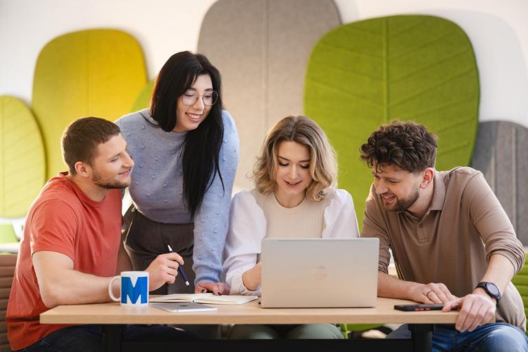 Osiągnięcia naukowe KK | Uniwersytet WSB Merito Szczecin: Grupa studentów Uniwersytetu WSB Merito wspólnie pracująca przy laptopie