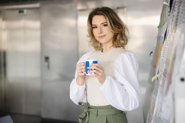 Psychologia rozwoju osobistego | Studia I stopnia w Szczecinie | Uniwersytet WSB Merito Szczecin: Studentka Uniwersytetu WSB Merito Szczecin z kubkiem kawy przy tablicy.