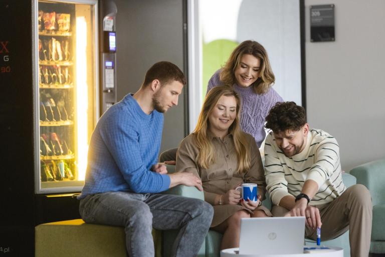 Pośrednictwo pracy | Uniwersytet WSB Merito Szczecin: Czworo studentów Uniwersytetu WSB Merito siedzi w strefie relaksu, pracując wspólnie przy laptopie.