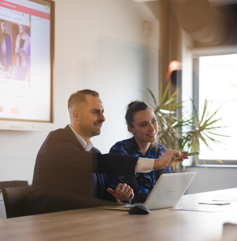 Neurologopedia | Studia podyplomowe w Szczecinie | Uniwersytet WSB Merito Szczecin: Dwie osoby pracują przy laptopie, omawiając prezentację.