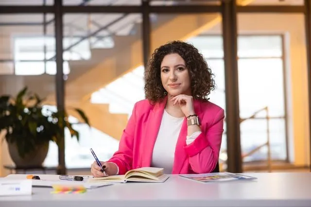 Wczesne wspomaganie rozwoju | Studia podyplomowe w Szczecinie | Uniwersytet WSB Merito Szczecin: studentka przy biurku na uczelni WSB Merito Szczecin