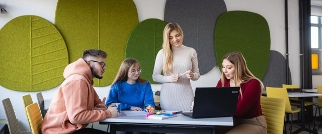 Logistyka usług portowych | Studia II stopnia ze studiami podyplomowymi  | Uniwersytet WSB Merito Szczecin: Studenci robiący projekt przy stole na uczelni