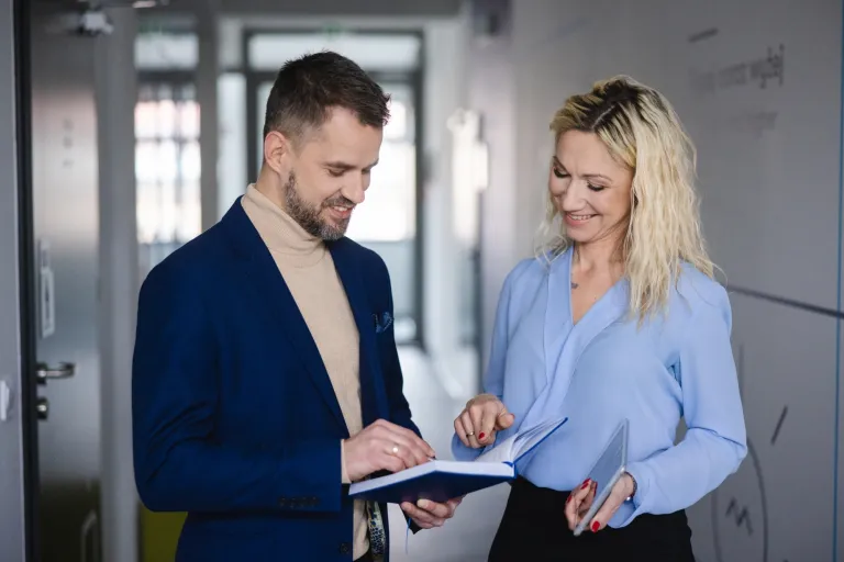 Wizaż i stylizacja | Studia podyplomowe w Szczecinie | Uniwersytet WSB Merito Szczecin: Uczestnicy MBA na korytarzu uczelni, kobieta i mężczyzna- Uniwersytet WSB Merito Szczecin