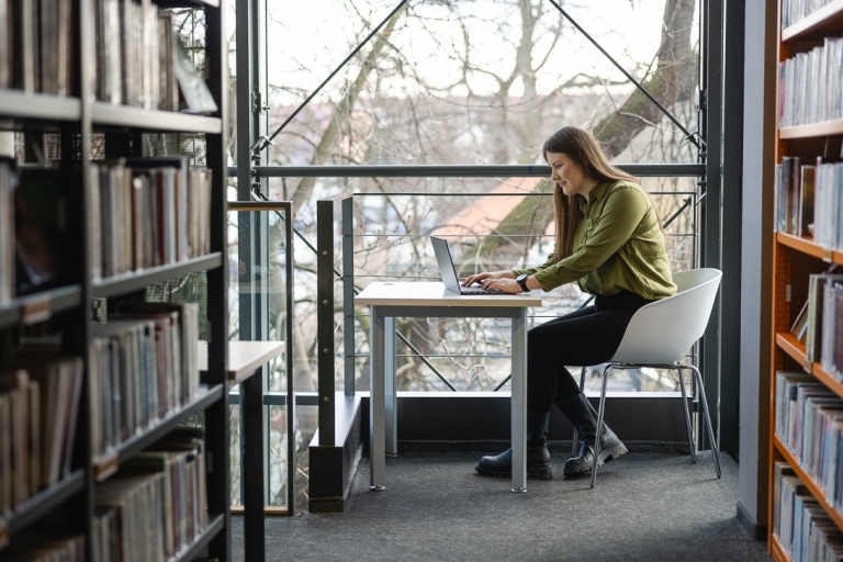 ESG i zrównoważony rozwój | Szkolenia i kursy w Szczecinie | Uniwersytet WSB Merito Szczecin: studentka w bibliotece