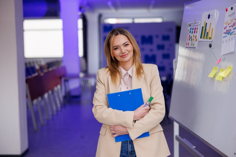 Dietetyka kliniczna | Studia I stopnia w Szczecinie | Uniwersytet WSB Merito Szczecin: Kobieta z teczką i markerem stoi przy tablicy.