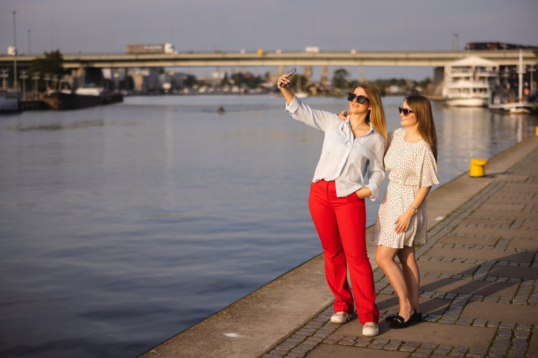 Menadżer przedsiębiorstwa turystycznego | Studia I stopnia w Szczecinie | Uniwersytet WSB Merito Szczecin: Dwie kobiety robią selfie nad wodą.