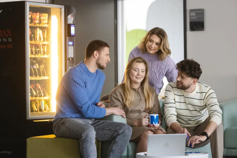 Logistyka usług portowych | Uniwersytet WSB Merito Szczecin: Grupa studentów pracuje wspólnie przy laptopie prowadząc luźną rozmowę.