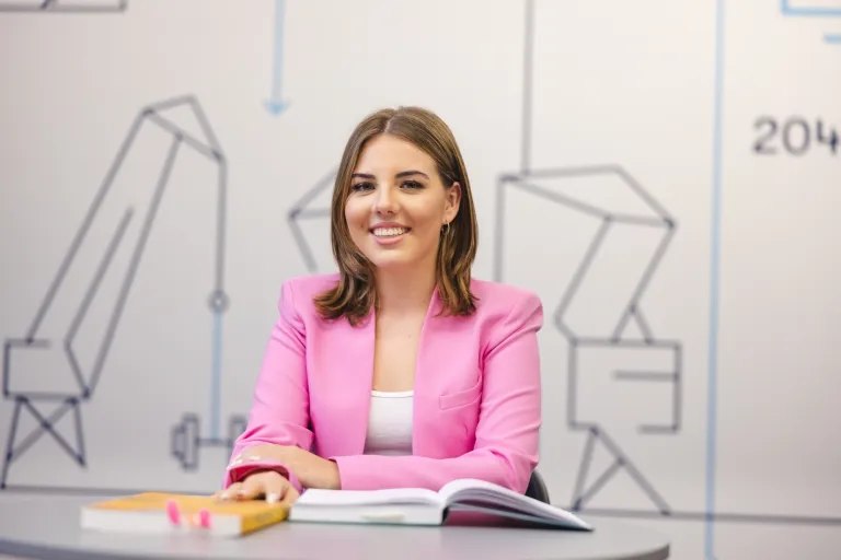 Pedagogika przedszkolna i wczesnoszkolna | Studia jednolite magisterskie w Szczecinie | Uniwersytet WSB Merito Szczecin: Studentka WSB Merito Szczecin siedzi przy stole z książkami