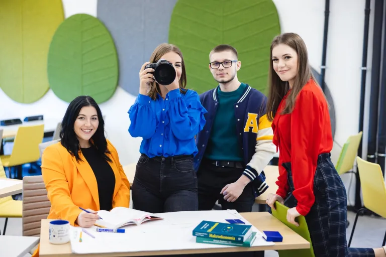 Weź udział w bezpłatnej sesji zdjęciowej i zostań twarzą Uniwersytetu! | Aktualności | Uniwersytet WSB Merito Szczecin: Studenci Uniwersytetu WSB Merito w sali kreatywnej, dziewczyna robi zdjęcie