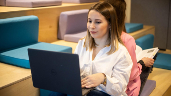 Web Application Developer | Studia I stopnia w Toruniu | Uniwersytet WSB Merito w Toruniu: studentka z laptopem na kolanach