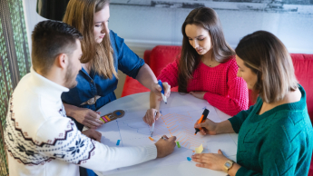 Projektowanie komunikacji produktowej | Studia I stopnia w Toruniu | Uniwersytet WSB Merito w Toruniu: Główna grafika: Toruń - studia I stopnia - grupa studentów przy okrągłym stole