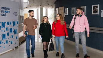 Projektowanie marki i wizerunku firmy | Studia I stopnia w Toruniu | Uniwersytet WSB Merito w Toruniu: Grupa czterech studentów idzie korytarzem uniwersytetu WSB Merito w Toruniu