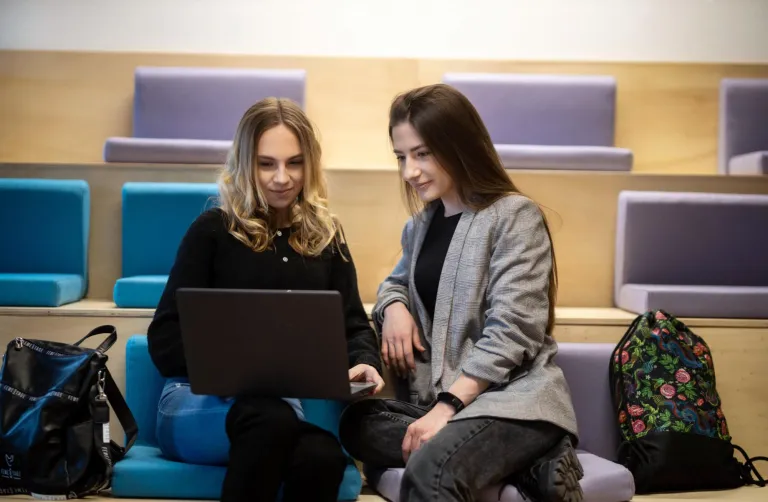 Cyfrowy uniwersytet | Uniwersytet WSB Merito w Toruniu: dwie studentki siedzą i patrzą w ekran laptopa