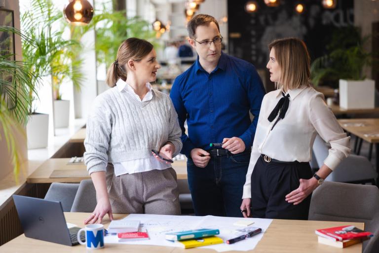 Centrum Transferu Technologii | Uniwersytet WSB Merito w Toruniu: Główna grafika: Toruń - studia SP - grupa ludzi rozmawia przy projekcie