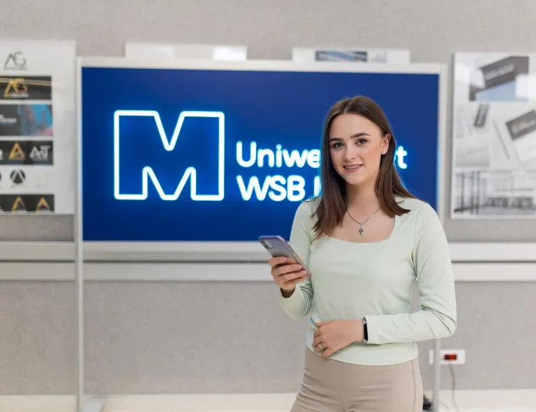 Rankingi i akredytacje | Uniwersytet WSB Merito w Toruniu: Główne zdjęcie: Dziekanat - Uniwersytet WSB Merito Toruń - uśmiechnięta studentka na korytarzu uczelni