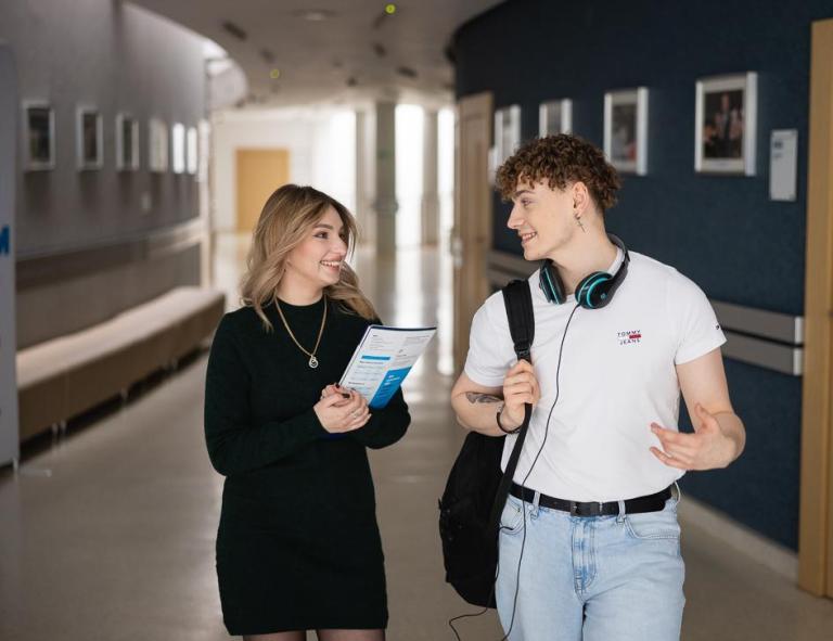 Strefa studenta | Uniwersytet WSB Merito w Toruniu: Dwoje studentów podczas rozmowy na korytarzu Uniwersytetu WSB Merito w Toruniu