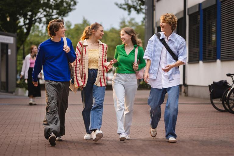 Kierunki inżynierskie - mniejsza inwestycja, ten sam zwrot! | Uniwersytet WSB Merito w Toruniu: Studenci idą i rozmawiają przed uczelnią